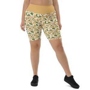 May include: White and yellow patterned bike shorts with a yellow waistband. The pattern features a repeated design of ginger root slices and leaves.