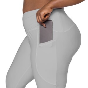May include: Gray leggings with a large pocket on the right side, a cell phone is partially visible in the pocket.
