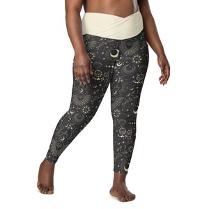 May include: Black leggings with a white waistband and a celestial print featuring moons, stars, and other celestial symbols.