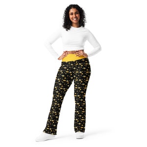 May include: Black leggings with a yellow waistband and a pattern of yellow beer mugs on a black background.