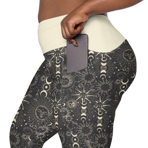 May include: Black leggings with a white waistband and a large pocket on the right side. The leggings feature a repeating pattern of suns and moons in a vintage style.