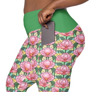 May include: Green leggings with a large phone pocket on the right side. The leggings have a floral pattern with pink flowers and green leaves.