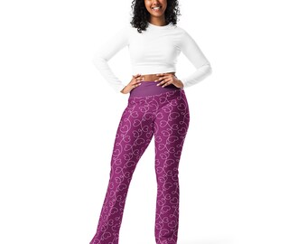 May include: A woman wearing a white long-sleeved shirt and pink leggings with a white heart pattern.