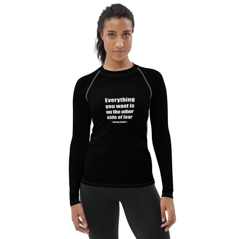 May include: Black long-sleeve shirt with a motivational quote: "Everything you want is on the other side of fear - George Addair".