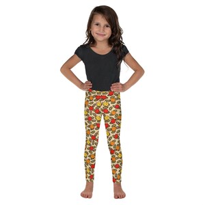 May include: A young person wearing a black short-sleeved shirt and colorful leggings with a pattern of yellow, orange, and red cartoon explosions.