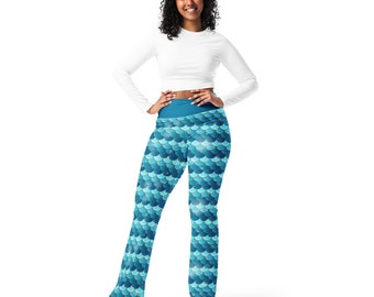 May include: A woman wearing blue and teal leggings with a mermaid scale pattern. The leggings have a high waist and a fitted silhouette.