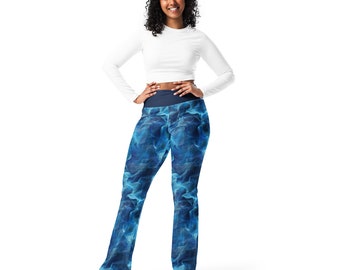May include: A woman wearing a white long-sleeved shirt and blue leggings with a blue flame pattern.