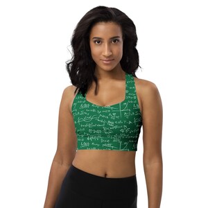 May include: A green sports bra with a white print of mathematical equations and formulas. The bra has a racerback style and is made of a stretchy, breathable fabric.