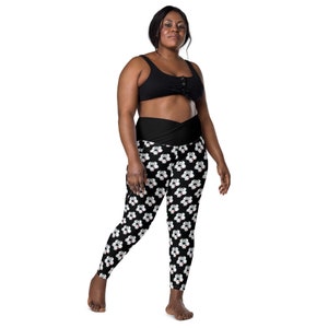 May include: Black leggings with a white cartoon animal print. The leggings have a high waist and a wide waistband.