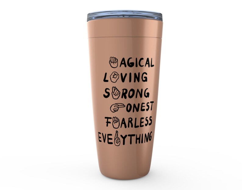 K&ouml;nnte beinhalten: Ein ros&eacute;goldener Becher mit einem schwarzen Design, auf dem "MAGICAL LOVING STRONG HONEST FEARLESS EVERYTHING" mit Geb&auml;rdensprachsymbolen f&uuml;r jedes Wort steht.