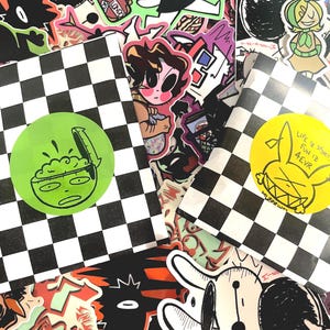 May include: Two packages with black and white checkered patterns, each with a circular sticker. One sticker is green with a brain graphic, the other is yellow with a rabbit graphic and the text "LIFE IS SHORT, FUN 12 4EVR". The background is covered in various stickers.