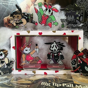 May include: Acrylic figurines featuring cartoon characters in various poses. The characters are dressed in costumes, including bunny ears and masks. Some hold weapons or props. The figurines are displayed in a decorative box with a heart-themed border.
