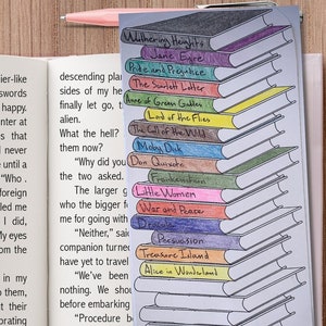 Puede incluir: Un libro abierto con texto y un marcapáginas de cinta rosa, junto a una pila de notas adhesivas ilustradas con forma de libro. Las notas adhesivas presentan títulos como "Moby Dick" y "Little Women". Un portátil y bolígrafos rosas están en el fondo.