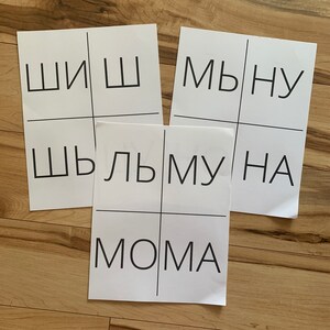 May include: Three white pieces of paper with black grid lines and black text. The text on the papers reads "ШШ", "ШЛЬМУНА", and "МВНУ" and "МОМА".