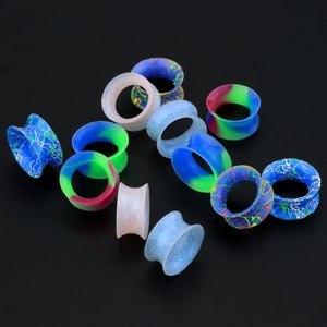 May include: Assortment of colorful silicone ear gauges with various patterns, including swirls, dots, and lines. The gauges are made of flexible silicone and come in a variety of sizes.