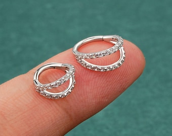 May include: Two silver hoop earrings with a double row of clear cubic zirconia stones.