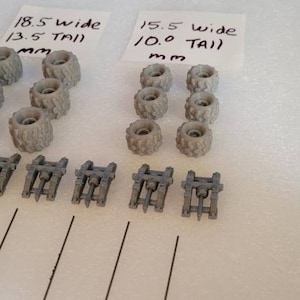 May include: A set of 18.5 wide by 13.5 tall mm and 15.5 wide by 10.0 tall mm gray plastic wheels with 6 wheels of each size. There are also 6 gray plastic axles.