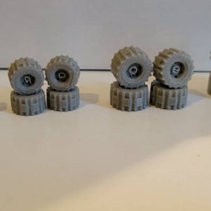 Off Road Tires with hole in center 1/64 scale. Silver 3d printed. 16 items all together. Different sizes.