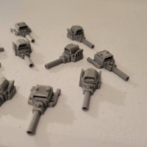 May include: Nine gray plastic model engine parts with different designs. Each part has a long, thin, cylindrical shaft and a detailed engine head.