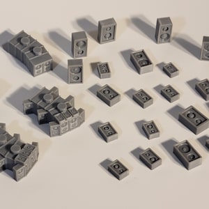 May include: A collection of gray 3D printed speaker models in various sizes and shapes. The models are arranged on a white surface.