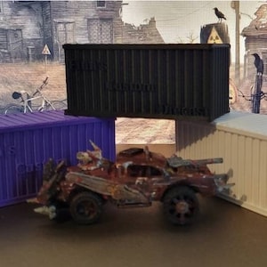 May include: Three miniature cargo containers, one purple, one black, and one beige, are stacked on top of each other. A rusty, brown toy car is in front of the containers.