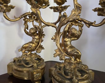 A pair of ornate antique French gilt ormolu candelabras