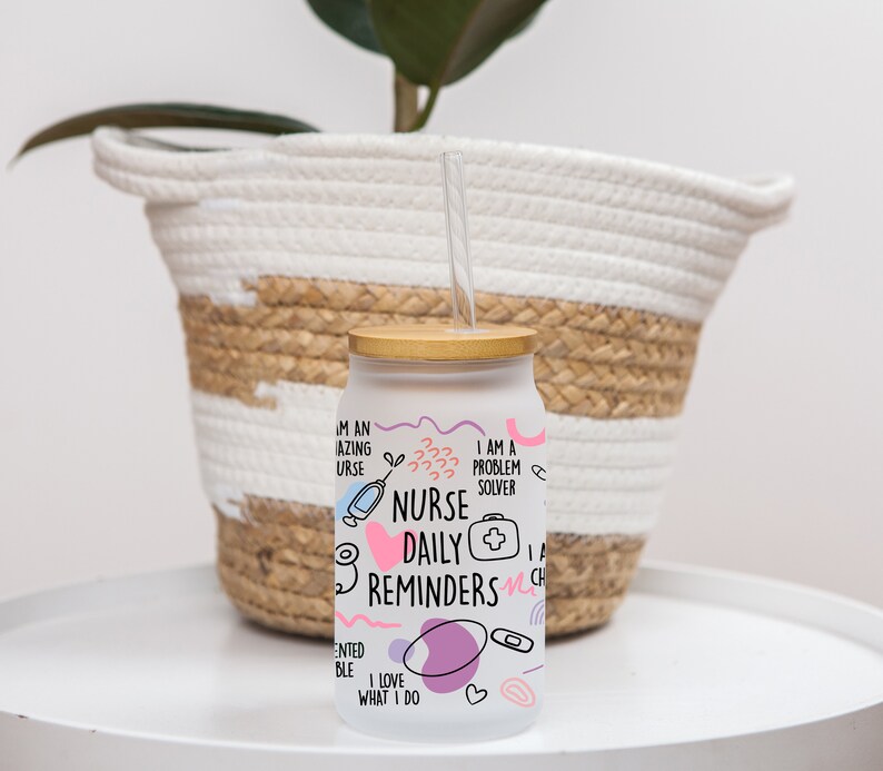 May include: White glass water bottle with a bamboo lid and a straw. The bottle has a pink and purple design with the text "Nurse Daily Reminders" and other related phrases.