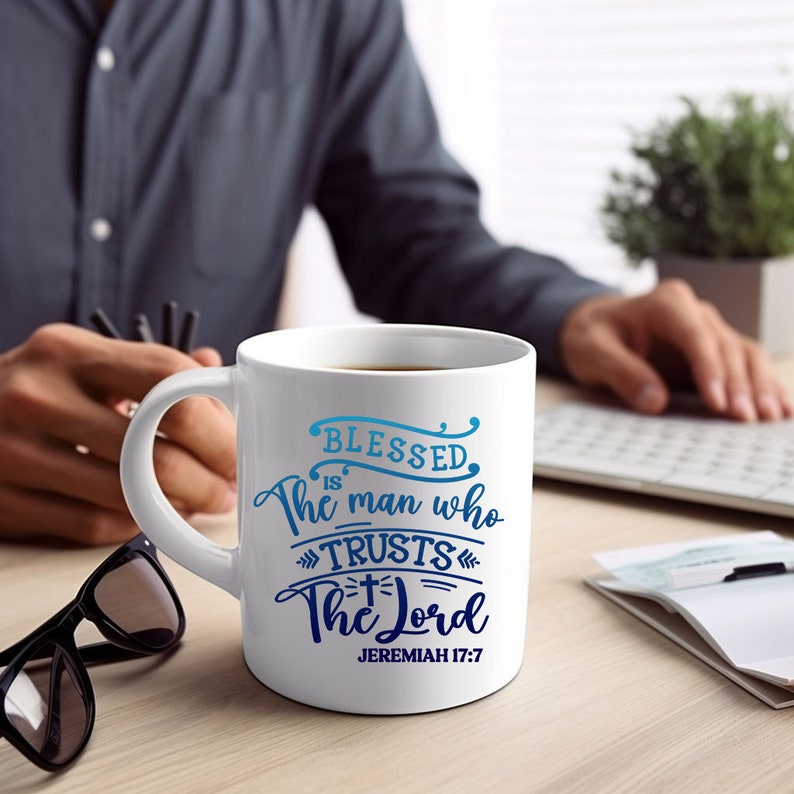 May include: White ceramic coffee mug with a blue and white design. The mug features the text "Blessed is the man who trusts the Lord" and "Jeremiah 17:7".