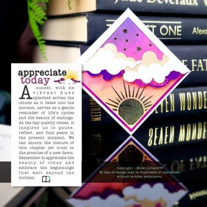 May include: A diamond-shaped bookmark featuring a sunset scene with a purple and pink gradient sky, white clouds, and a golden sun. The bookmark includes text that reads "appreciate today" and a paragraph about sunsets and life cycles.