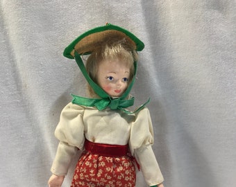 House of Hatten porcelain doll, prairie baby doll, white and red dress, bonnet and basket, blonde hair, 8" tall