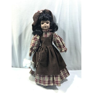 Vintage porcelain bisque doll, black hair brown eyes, brown red dress hat, teddy