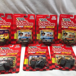 Op de afbeelding: Collectie van 1996 Racing Champions NASCAR 1/64 schaalmodel stockcars. Elke auto zit in de originele verpakking, met heldere kleuren en teamlogo's. De verpakking bevat het Racing Champions-logo en het NASCAR-logo.