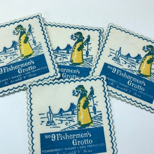 Puede incluir: Conjunto de cinco posavasos de papel vintage. Cada posavasos presenta una ilustración azul y amarilla de un pescador, un puente y un barco, con el texto "No. 9 Fisherman's Grotto, Fisherman's Wharf, San Francisco."