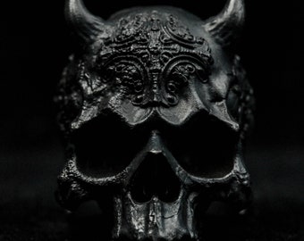 May include: A black skull with horns and intricate detailing. The skull is made of a smooth, dark material and has a menacing expression.