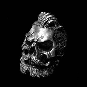 May include: A silver skull ring with a detailed design of a beard and a pompadour hairstyle.