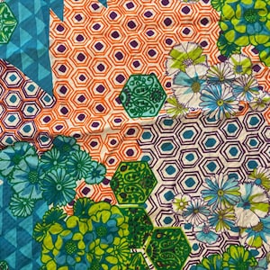 May include: A colorful fabric with a geometric pattern of hexagons and flowers in shades of blue, green, orange, and white.