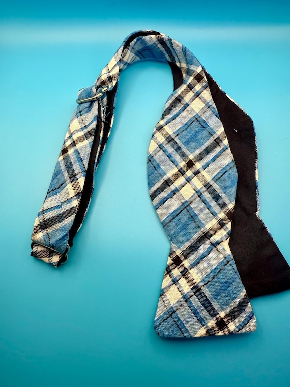 Blue plaid with silver self tie bow tie with silver hardware and light blue back.