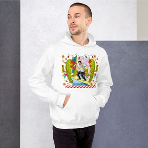 Può includere: Felpa bianca con un'illustrazione colorata di un uomo con un sombrero che sta in piedi tra due cactus. L'illustrazione include il testo "El Borracho".