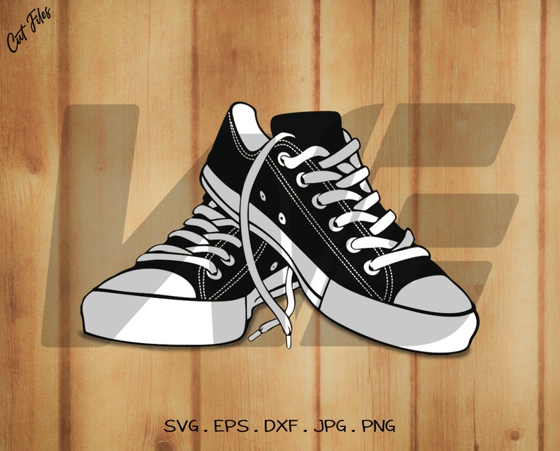 May include: A pair of black canvas sneakers with white laces and white soles. The sneakers are tied together and are lying on a woodgrain background.