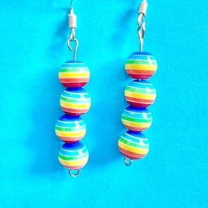 May include: Rainbow striped bead earrings with silver hooks. Each earring has four beads.
