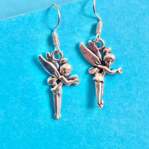 Puede incluir: Un par de pendientes de plata con un dise&ntilde;o de hada. Cada pendiente tiene una delicada figura de hada con alas y un vestido fluido.