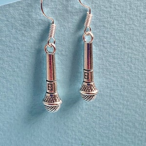 Op de afbeelding: Een paar zilveren microfoon oorbellen. De oorbellen zijn zilver en hebben een microfoon ontwerp.