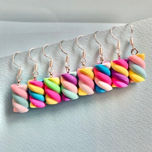 May include: A set of eight colorful, twisted marshmallow-shaped earrings. Each earring is a different color combination of pink, blue, yellow, green, and purple.