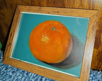 May include: A painting of a single orange on a teal background. The orange is in focus and has a slight shadow underneath it.