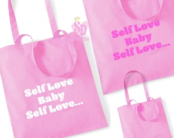 May include: Three pink tote bags with white text that reads "Self Love Baby Self Love..." The bags are made of canvas and have long handles.