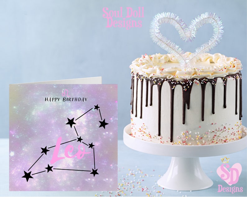Puede incluir: Una tarjeta de cumplea&ntilde;os con tem&aacute;tica de galaxia rosa y morada con la constelaci&oacute;n de Leo y el texto "Feliz cumplea&ntilde;os". En el fondo hay un pastel blanco con glaseado de chocolate y chispas.