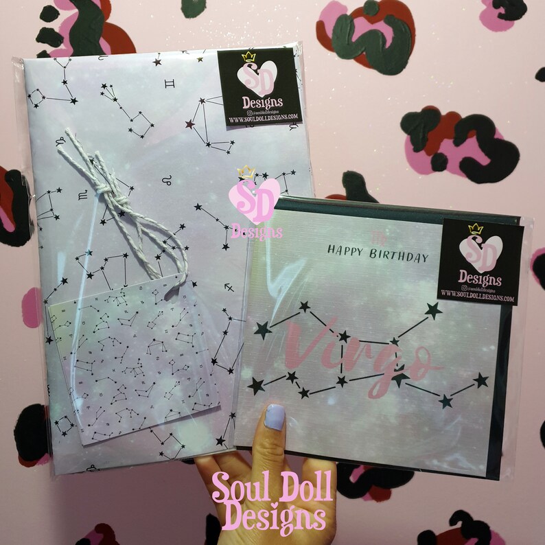 Puede incluir: Una tarjeta de cumplea&ntilde;os blanca y rosa con un borde negro y un dise&ntilde;o de constelaci&oacute;n de Virgo rosa. La tarjeta dice "Feliz cumplea&ntilde;os" y tiene un peque&ntilde;o logotipo en la esquina que dice "Soul Doll Designs".