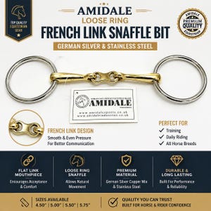 May include: An Amidale loose ring French link snaffle bit made of German silver and stainless steel. The bit features a gold-coloured mouthpiece with a central flat link and silver-coloured rings. A white product tag with the Amidale logo is attached.