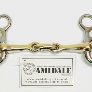 May include: A silver and gold-coloured metal horse bit with a jointed mouthpiece and two rings on each side. A white rectangular tag is attached, featuring the text AMIDALE INDUSTRIES, a horse logo, and the website addresses amidalesports.co.uk and amidaleindustries.co.uk.