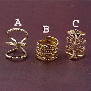 May include: Three gold-toned rings labeled A, B, and C. Ring A features a double-band open design. Ring B is a multi-coil band with a textured pattern. Ring C displays a detailed tree silhouette integrated into the band structure.